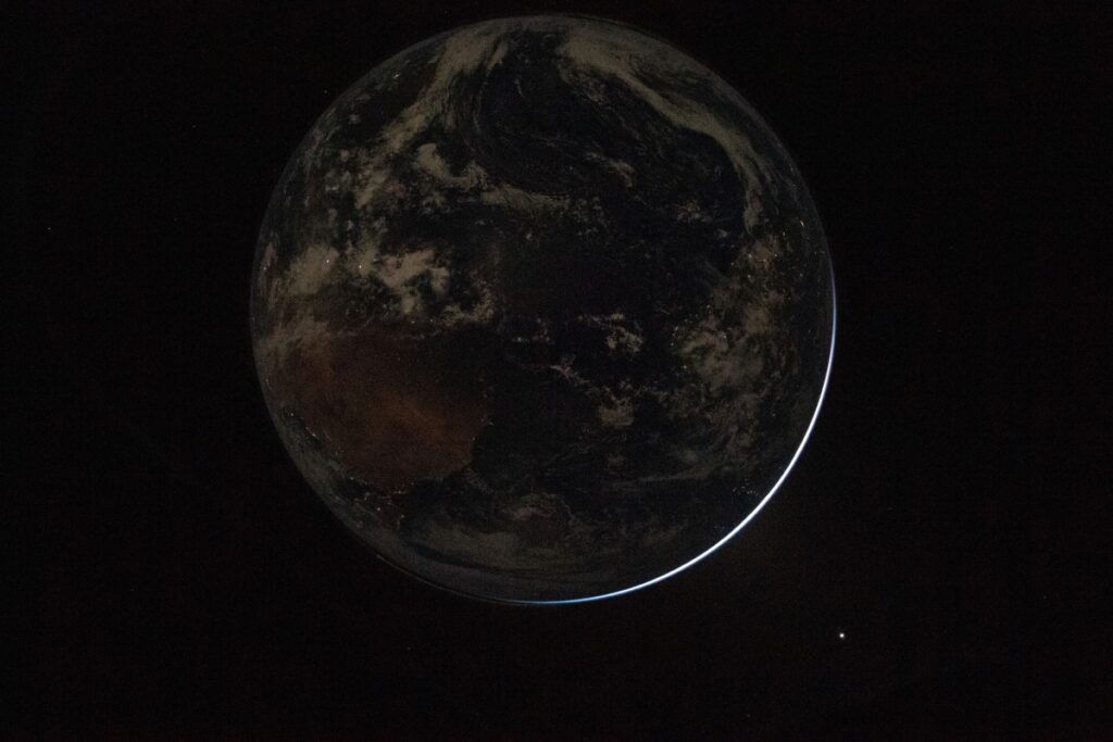 Earth view from Orion spacecraft showing electric lights of human activity and sunlight on the planet’s limb, taken by NASA astronaut Reid Wiseman during Artemis II mission - Too Lazy Facts